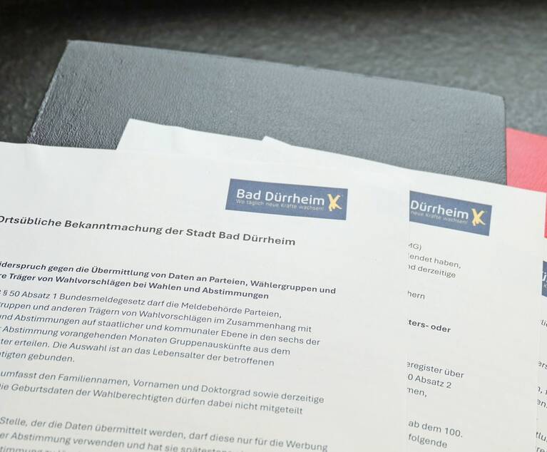 Bedruckte Papiere liegen aufgefächert auf Schreibmappen