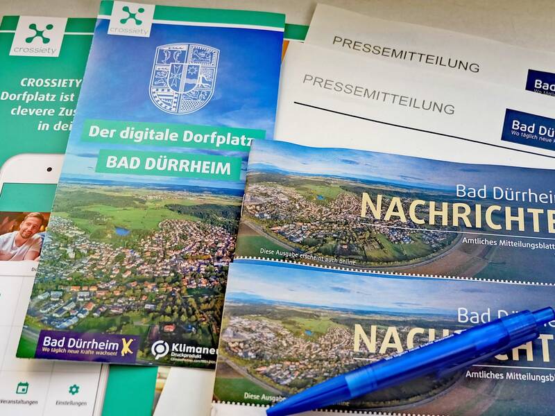 Verschiedene Flyer und Mitteilungen sowie ein Stift