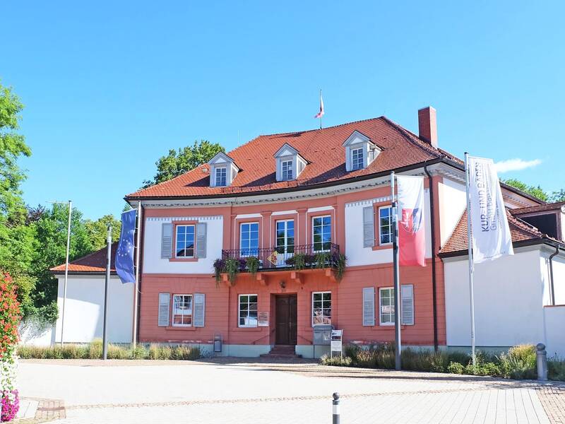 Bad Dürrheimer Rathaus mit Balkon und Flaggen sowie Blumenschmuck auf dem Rathausplatz