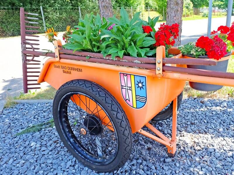 Eine Schubkarre mit Rechen und Blumendekoration