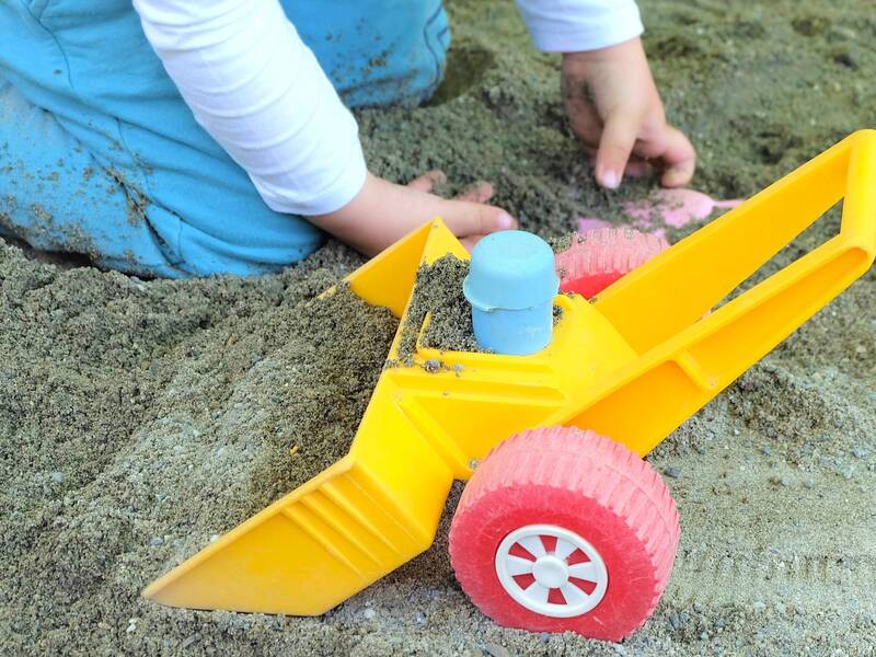 Sandkastenspielzeug und Kinderhände