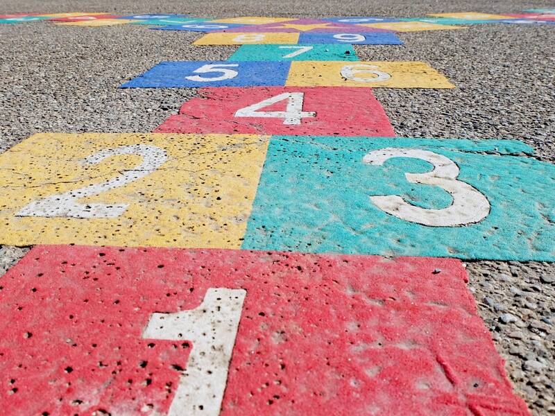 Bunte Kästchen mit Zahlen auf Aspahlt aufgemalt
