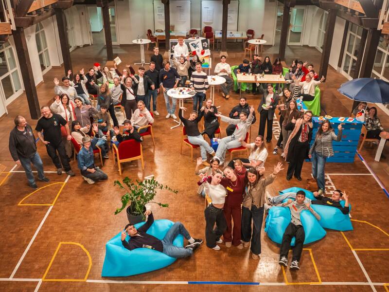 Viele Menschen in einem großen Saal von oben