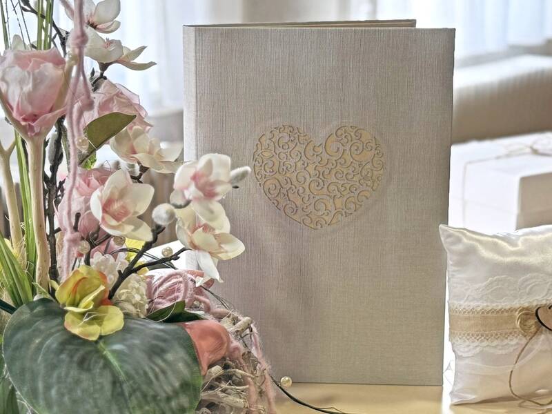 Blumengesteck, Stammbuch mit Herz und Ringkissen auf einem Tisch