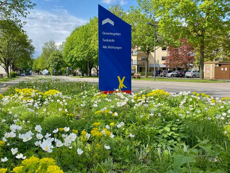 Ein Grünstreifen mit Blumen am Straßenrand