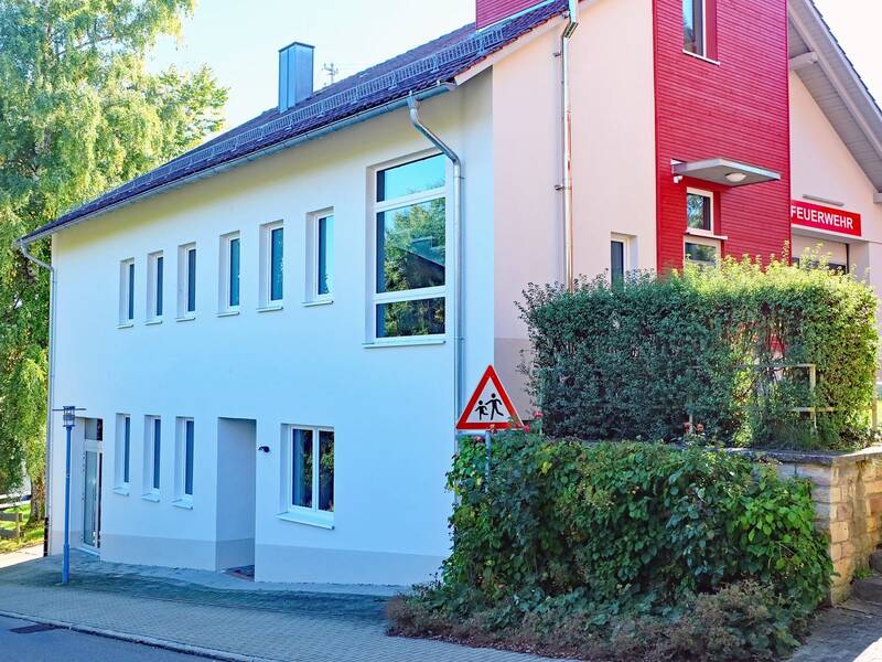Ein Gebäude mit vielen Fenstern und Hecken
