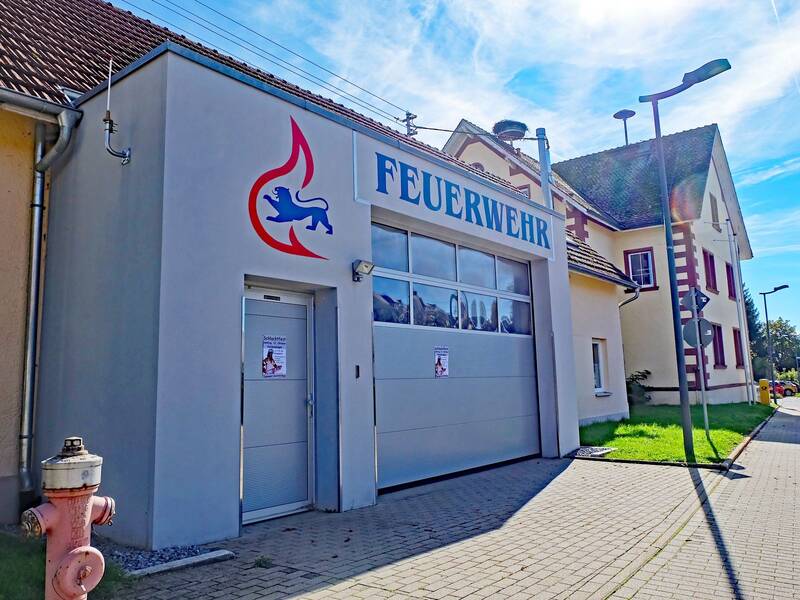 Ein Gebäude mit Tür und Rolltor sowie Aufschrift