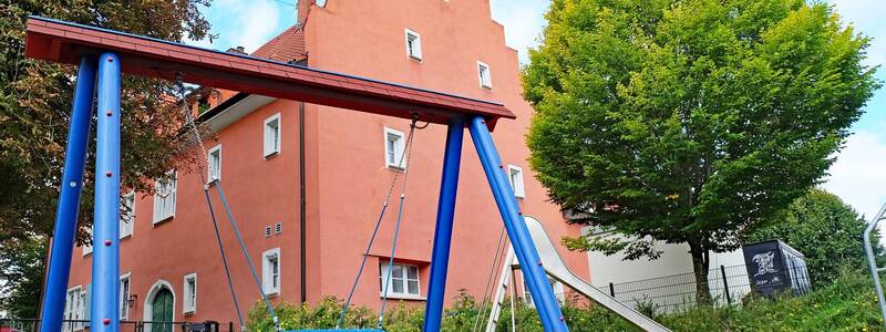 Eine Nestschaukel vor einem Gebäude mit stufigem Dachgiebel
