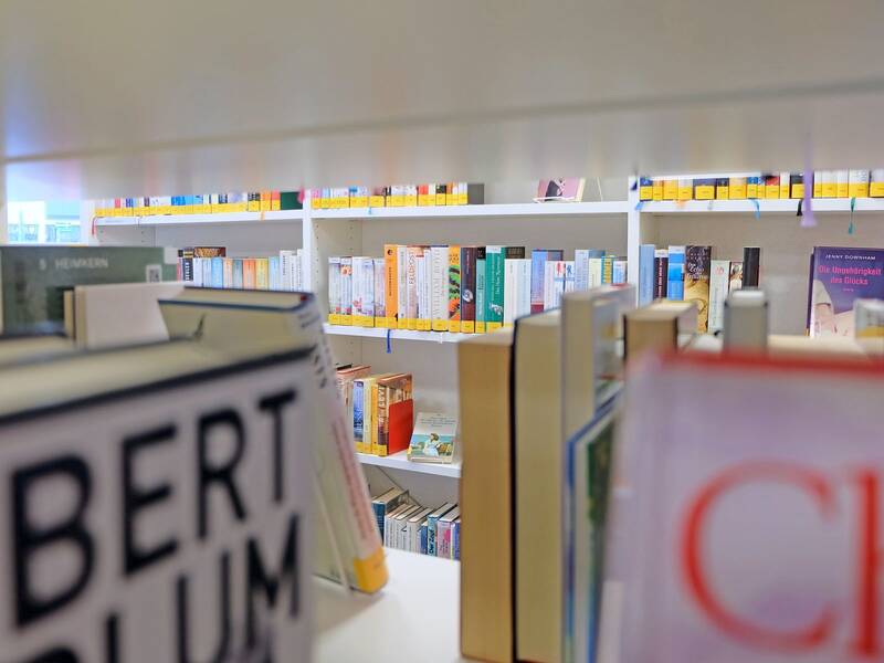 Blick zwischen Bücherregale hindurch
