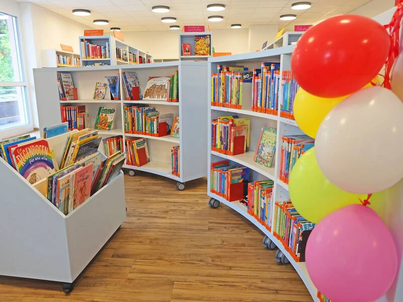 Halbrundes Bücherregal sowie Bücherkiste und Luftballondeko