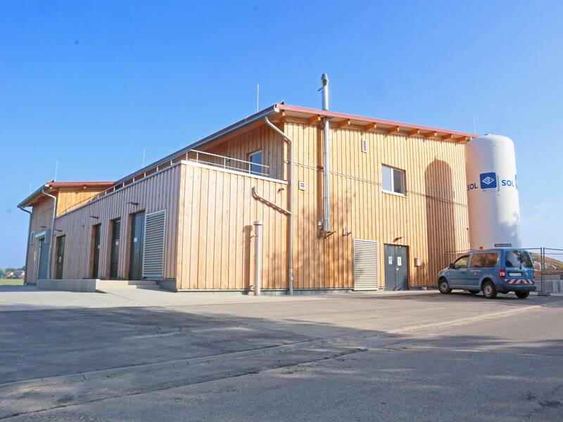 Modernes Gebäude mit Holzfassade und großem Kohlesäurespeicher aus Metall