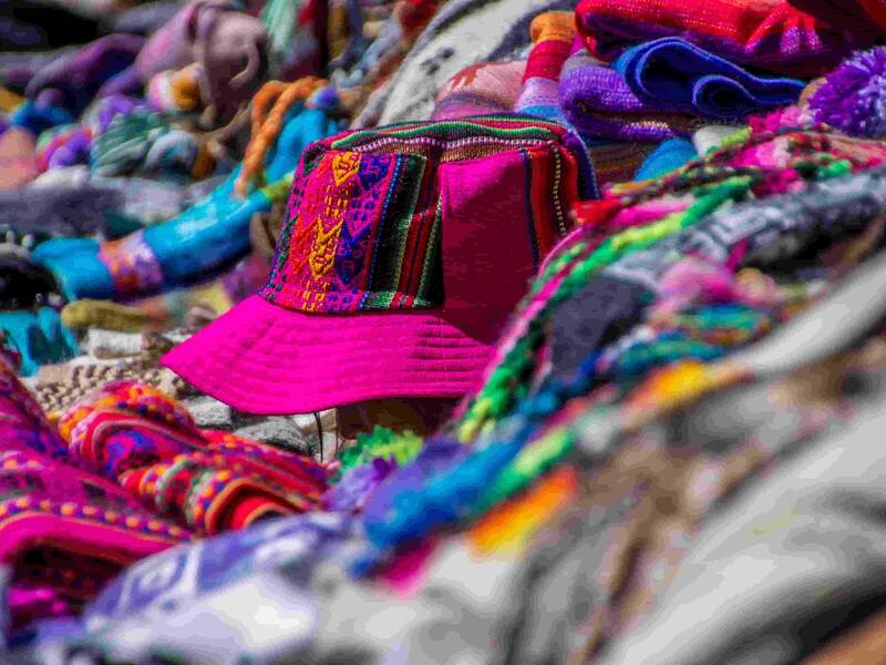 Bunte Stoffe in Form von Hüten und Mützen werden auf einer Auslage präsentiert
