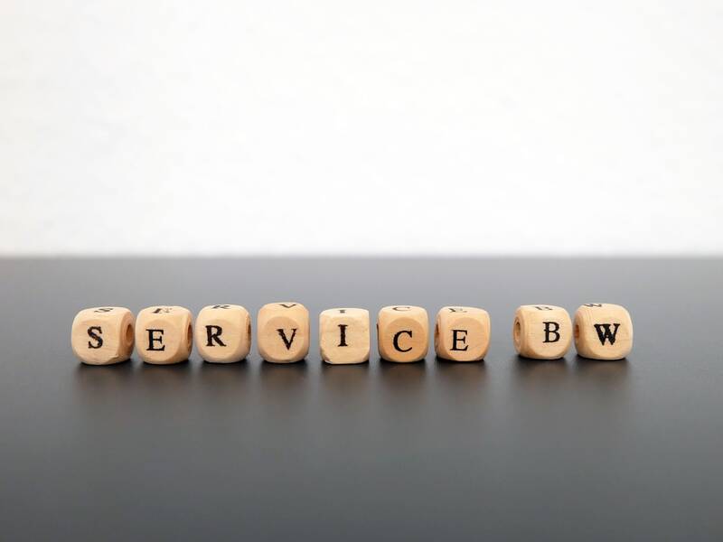 Buchstaben aus Holz ergeben das Wort Service BW